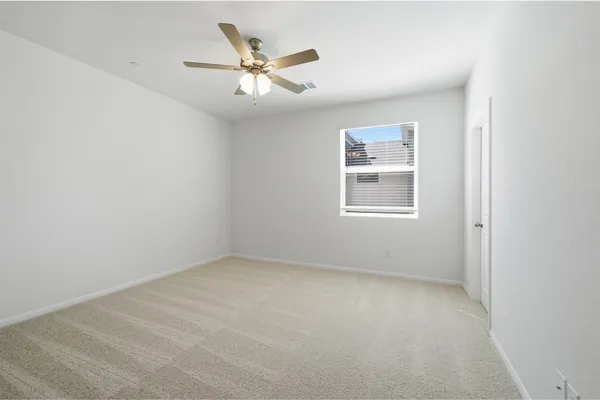 an empty room with a window and a fan