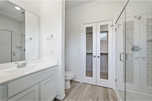 a bathroom with a double vanity sink toilet and shower