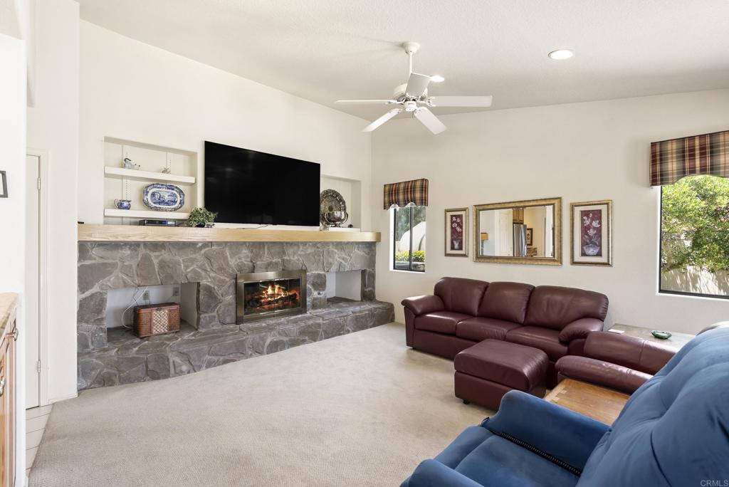2221 Cortina Circle Escondido, CA 92029 - Photo 12 of 36 a living room with furniture a fireplace and a flat screen tv