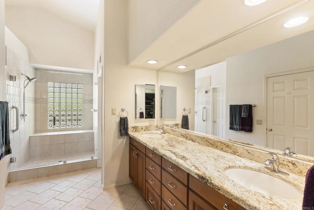 2221 Cortina Circle Escondido, CA 92029 - Photo 18 of 36 a spacious bathroom with a granite countertop tub sink and mirror