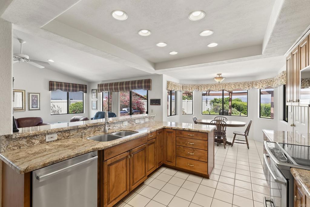 2221 Cortina Circle Escondido, CA 92029 - Photo 8 of 36 a kitchen with granite countertop a sink and white cabinets