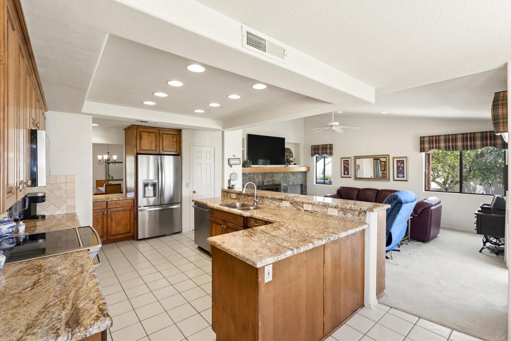 2221 Cortina Circle Escondido, CA 92029 - Photo 10 of 36 a large kitchen with sink a refrigerator and chairs