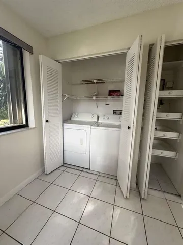 a kitchen with white cabinets and refrigerator
