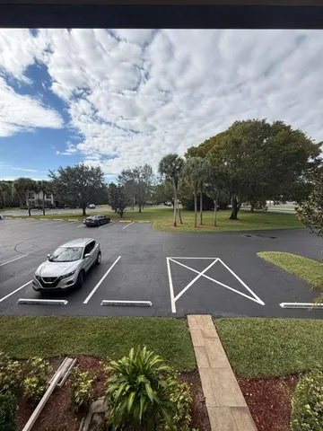 a view of a playground with yard and a car parked