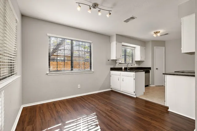a kitchen with granite countertop white cabinets and white appliances