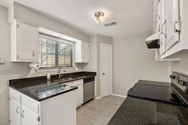a kitchen with a sink stove and cabinets