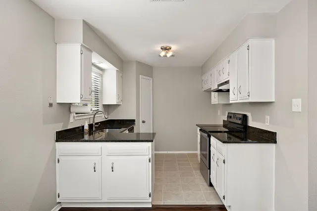 a kitchen with white cabinets and a sink