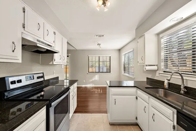 a kitchen with a sink stove top oven and cabinets