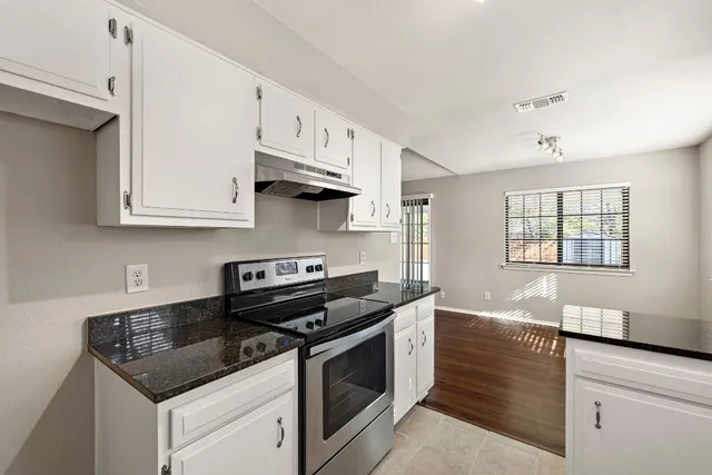 a kitchen with granite countertop a stove and a sink