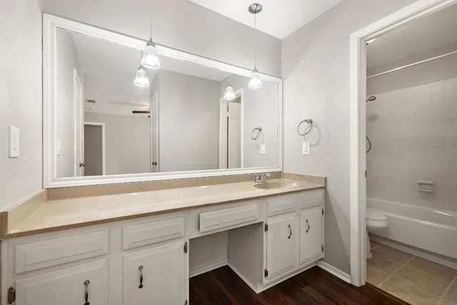a spacious bathroom with a granite countertop sink mirror and a