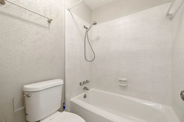 a bathroom with a toilet and a bath tub