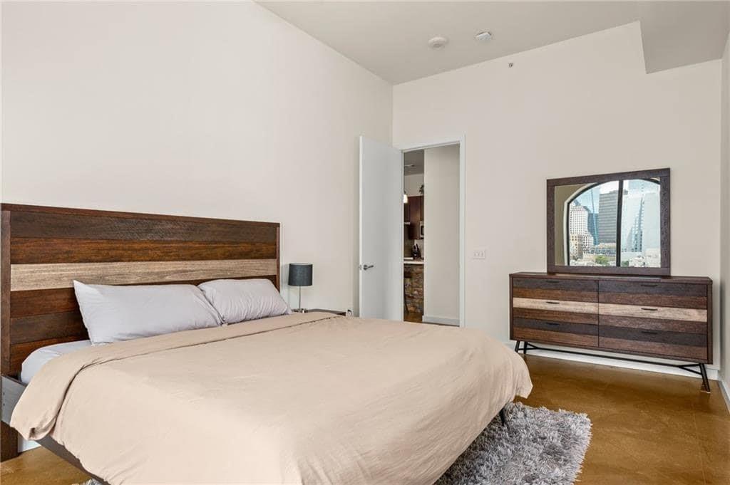 507 Sabine Street, Unit 705 Austin, TX 78701 - Photo 13 of 32 a bedroom with a bed and a mirror