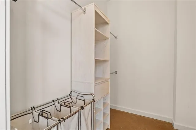 a view of walk in closet with empty racks