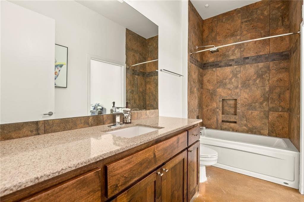 507 Sabine Street, Unit 705 Austin, TX 78701 - Photo 18 of 32 a bathroom with a granite countertop sink a mirror and a bathtub