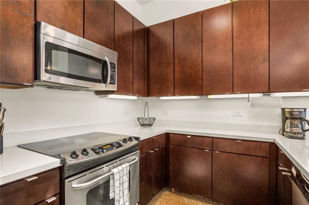 507 Sabine Street, Unit 705 Austin, TX 78701 - Photo 24 of 32 a kitchen with granite countertop cabinets stainless steel appliances and wooden cabinets