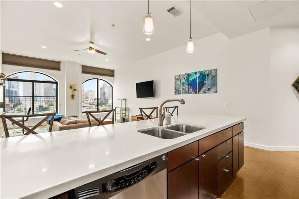 507 Sabine Street, Unit 705 Austin, TX 78701 - Photo 25 of 32 a kitchen with a sink a counter and cabinets