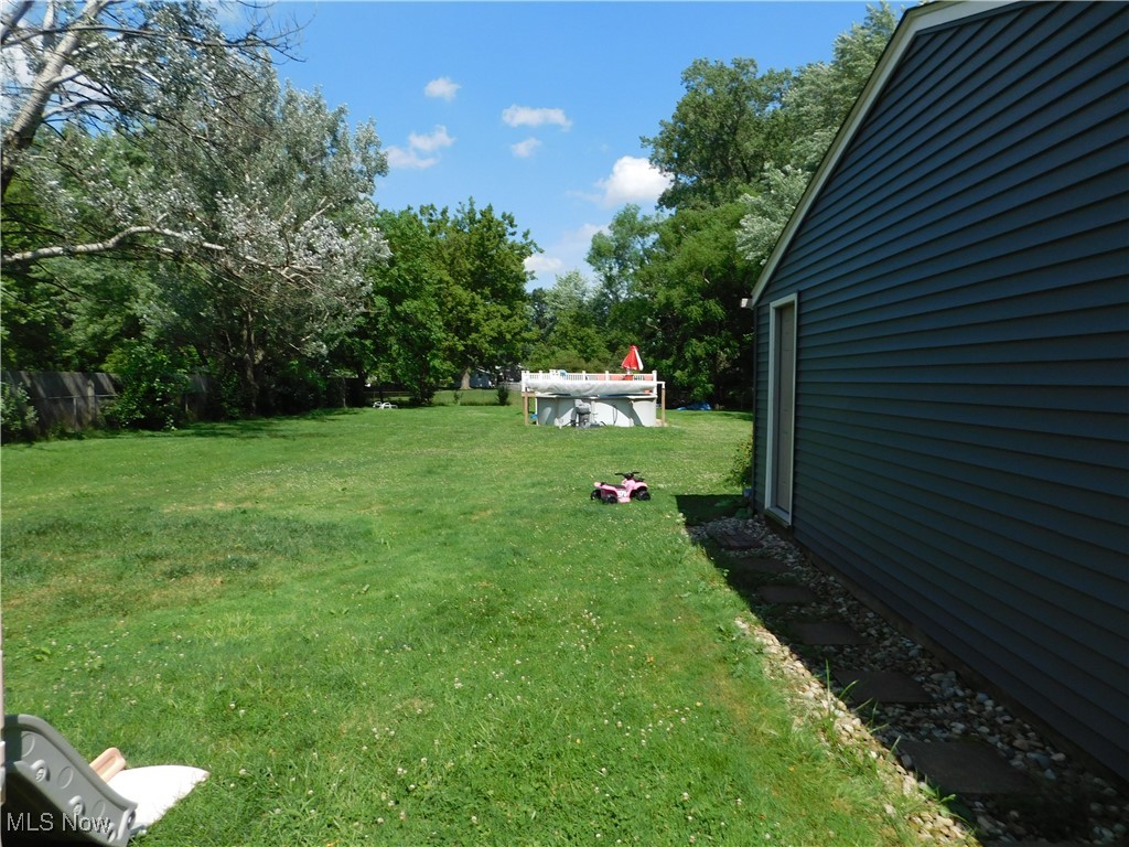 581 Hadcock Road Brunswick, OH 44212 - Photo 7 of 22 View of grassy yard featuring an outdoor pool and view of wooded area
