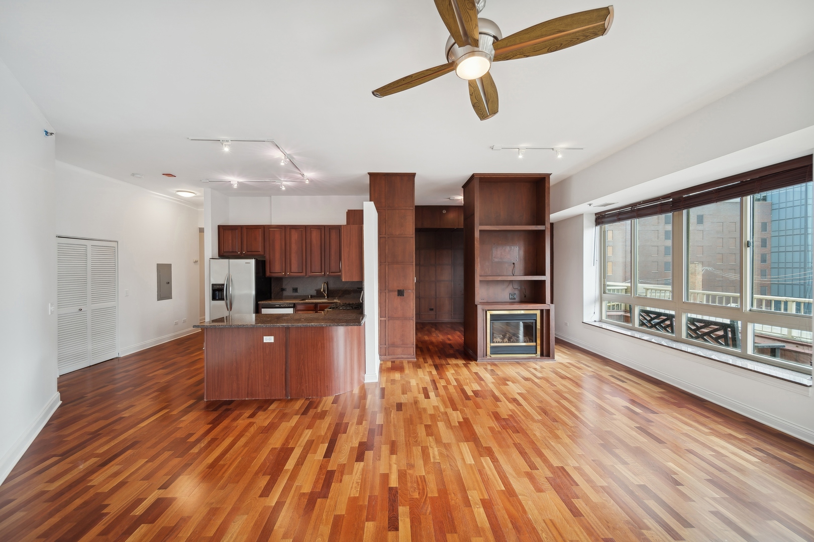 230 West Division Street, Unit 501 Chicago, IL 60610 - Photo 10 of 27 a large kitchen with stainless steel appliances kitchen island granite countertop a large window and a wooden floor