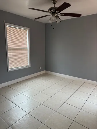 an empty room with windows and fan