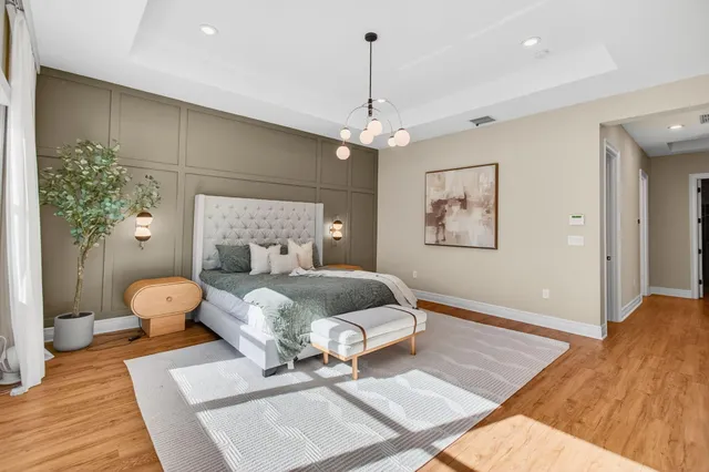 a bedroom with a large bed and a chandelier