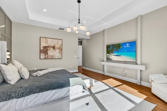 a bedroom with a bed wooden floor and window