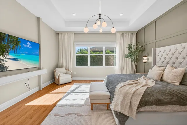 a bedroom with a bed chandelier and window