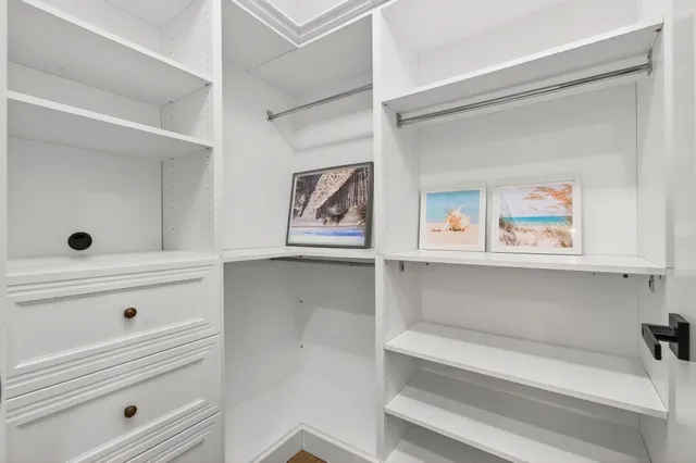 a front view of a house with a yard and potted plants