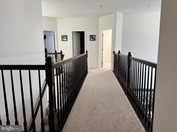 a view of a hallway with wooden floor and stairs