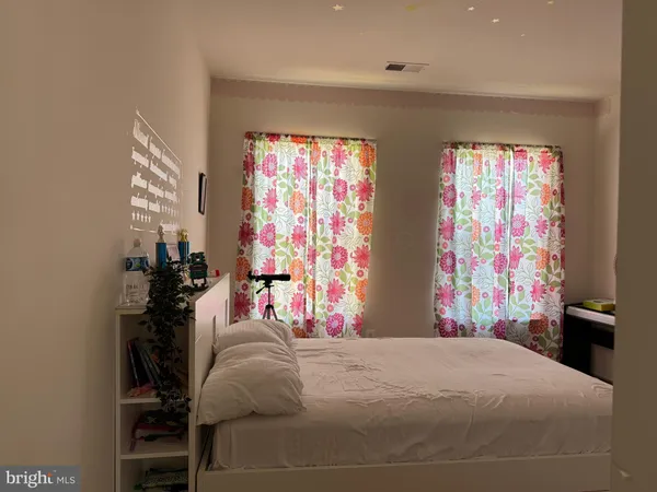 a bedroom with a bed and a lamp next to a window