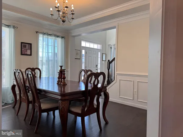 a view of a a dining room with furniture window and wooden floor
