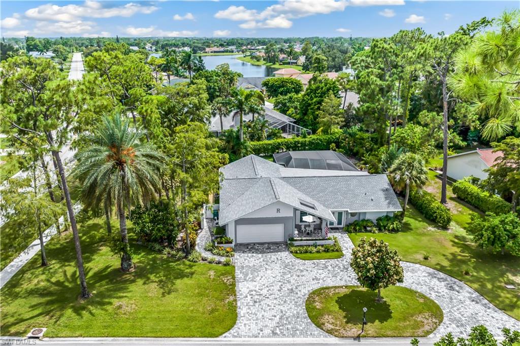 an aerial view of a house with a yard and lake view