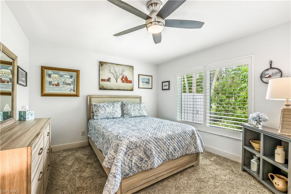 2232 Buckingham Lane Naples, FL 34112 - Photo 17 of 30 a bedroom with a bed bookshelf and a window