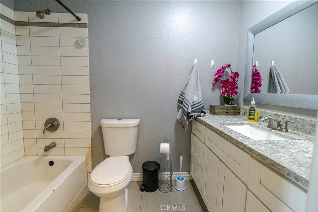16403 Seneca Road Victorville, CA 92395 - Photo 16 of 47 a bathroom with a granite countertop sink a toilet and bathtub