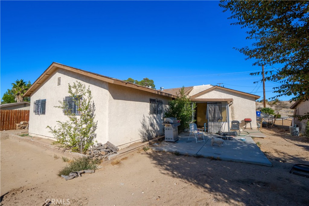 16403 Seneca Road Victorville, CA 92395 - Photo 30 of 47 a backyard of a house with table and chairs under an umbrella