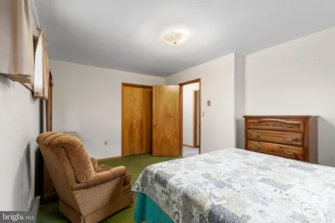 a bedroom with a bed dresser and a window