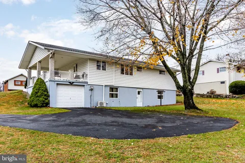 a view of a white house with a large tree