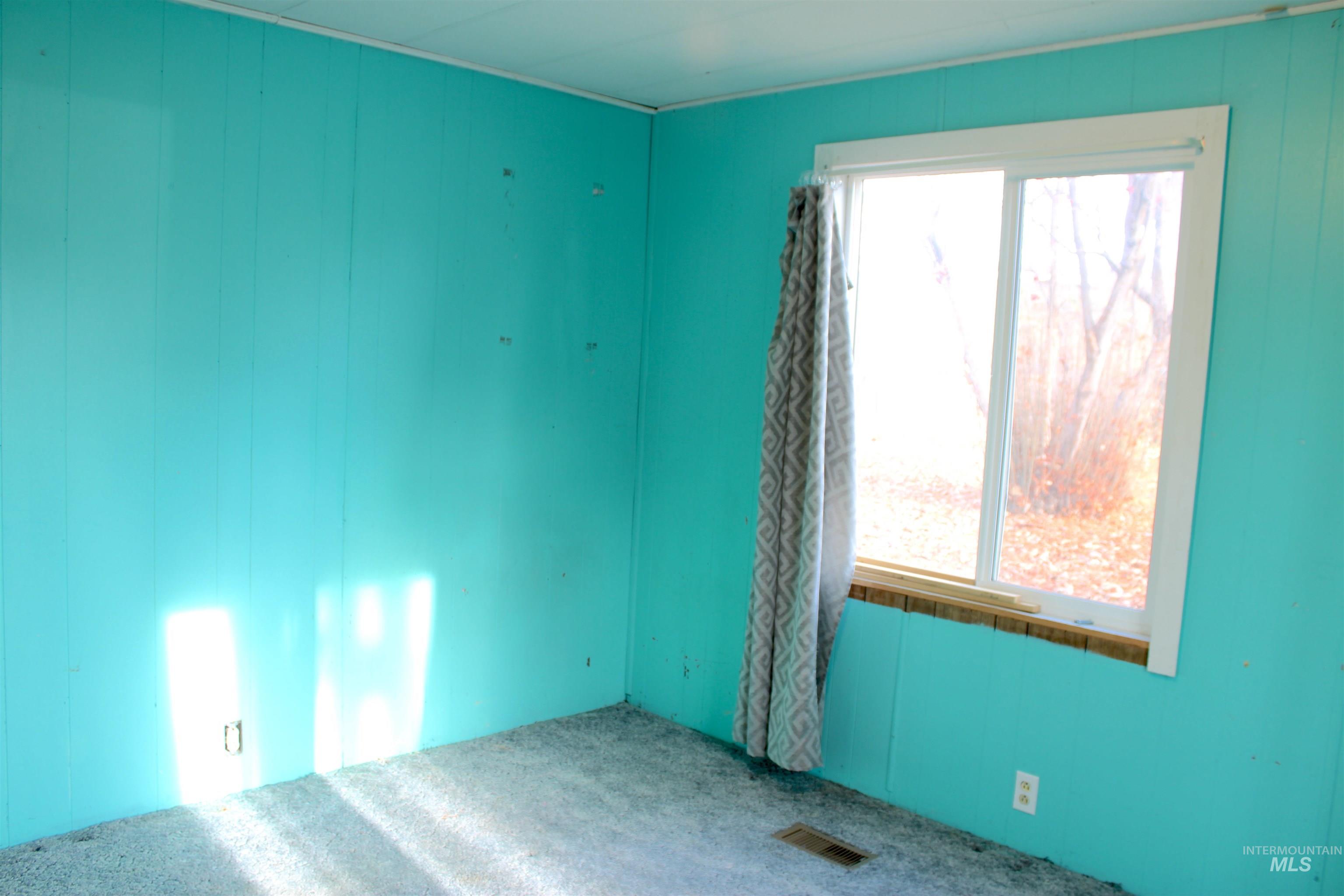 15881 Purple Sage Road, Unit 3 Caldwell, ID 83607 - Photo 19 of 29 Empty room with wood walls