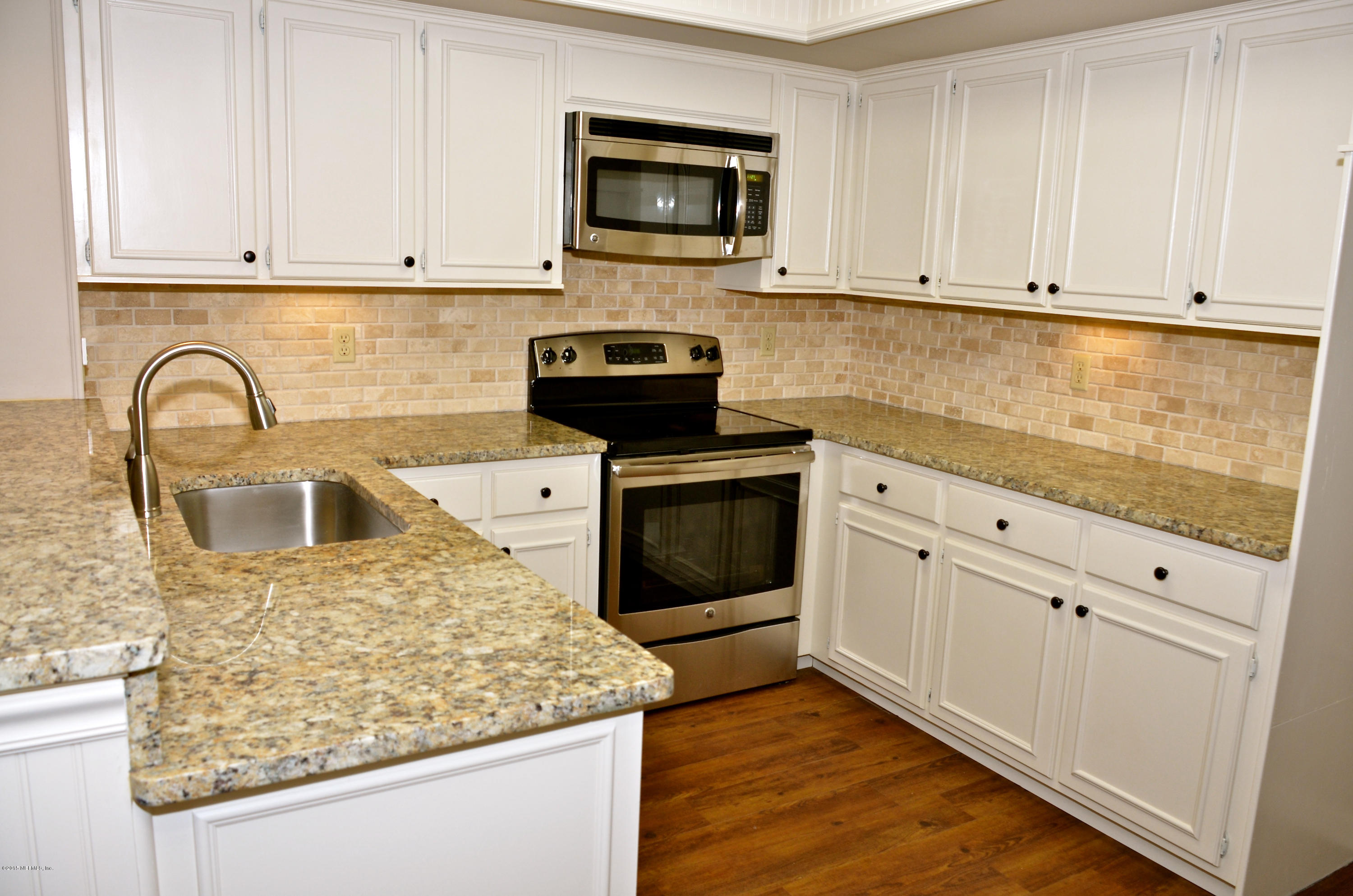 405 Tournament Road Ponte Vedra, FL 32082 - Photo 7 of 31 a kitchen with granite countertop white cabinets and stainless steel appliances