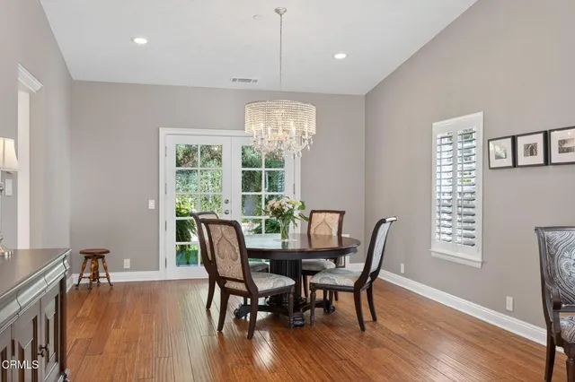 a dining room with furniture a chandelier and wooden floor