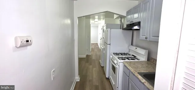 a kitchen with a refrigerator and a stove top oven