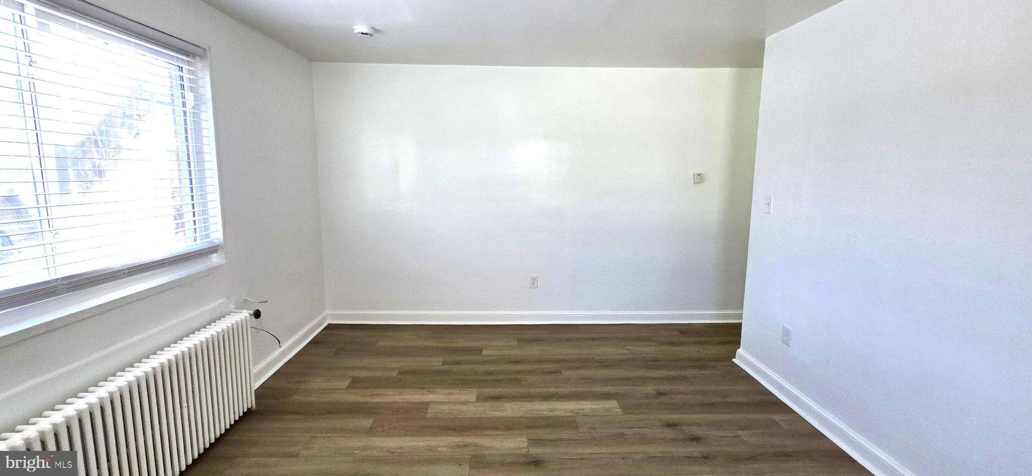 3207 11th Place Southeast, Unit 4 Washington, DC 20032 - Photo 6 of 16 a view of an empty room with wooden floor and a window