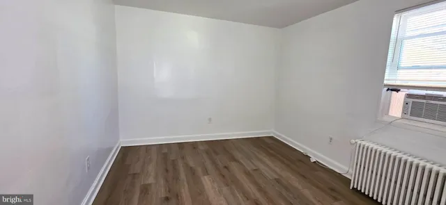 a view of a room with wooden floor and a window