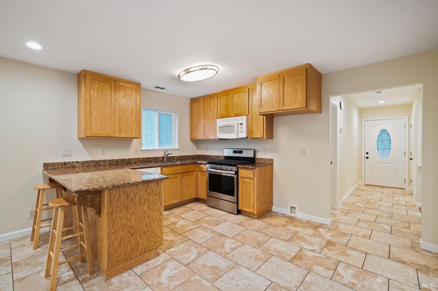 84 Front Street Camp Meeker, CA 95419 - Photo 6 of 24 a kitchen with stainless steel appliances granite countertop a stove a sink and a refrigerator