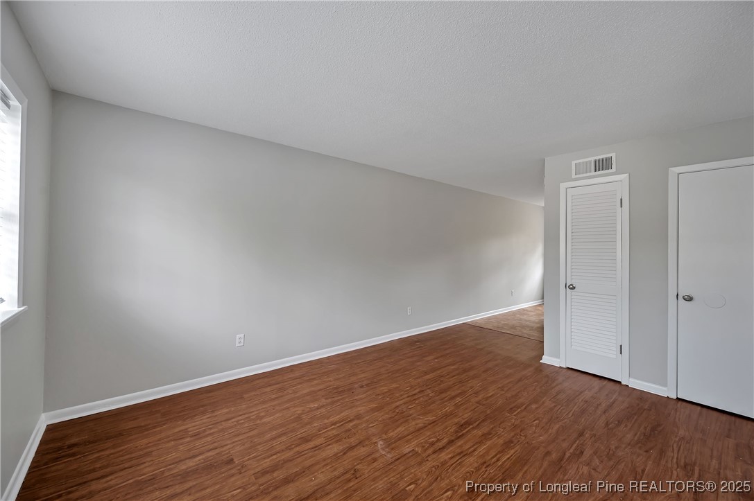 302 Law Road, Unit A Fayetteville, NC 28311 - Photo 7 of 8 a view of an empty room with wooden floor and a window