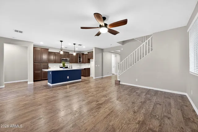 a view of kitchen and empty room with wooden floor
