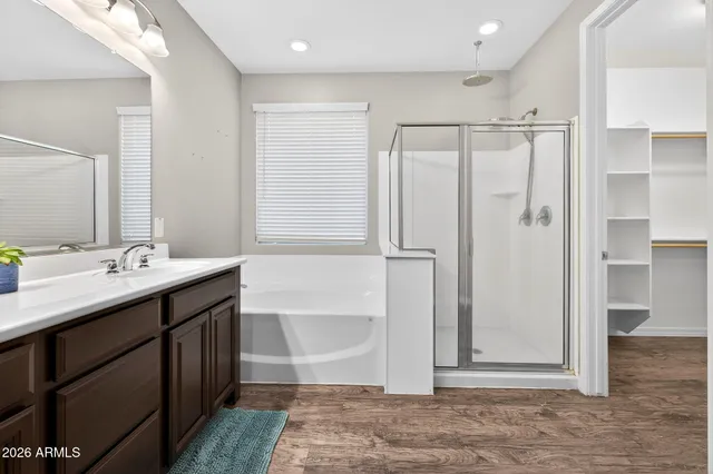 a bathroom with a tub sink shower and mirror