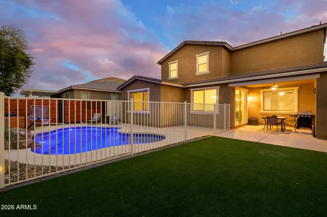 a view of a house with a swimming pool and a yard