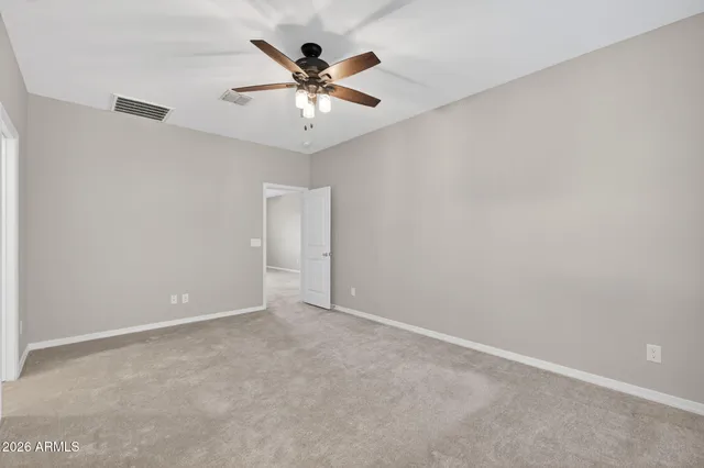 an empty room with chandelier fan