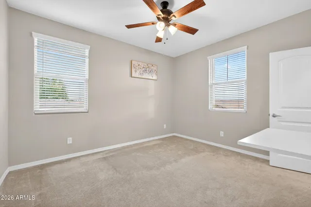 an empty room with closet and a ceiling fan