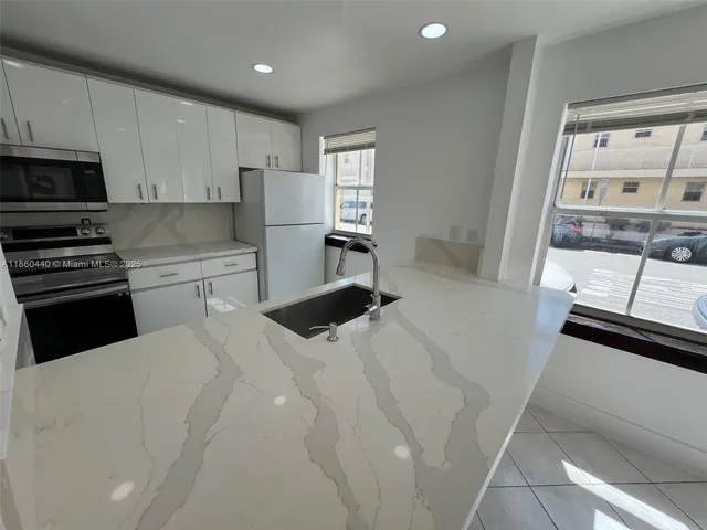 a kitchen with stainless steel appliances a refrigerator and a stove top oven